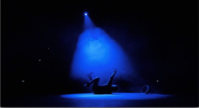 A lone figure under a blue spotlight