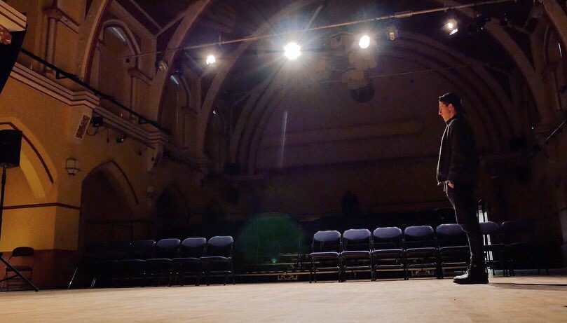 David on stage in a grand hall